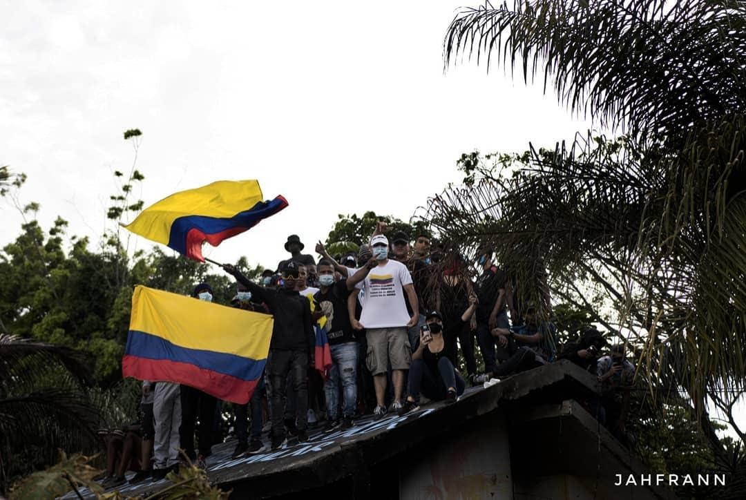 people on rooftop with flags of colombia people on rooftop with flags of colombia